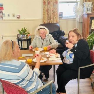A group of seniors enjoying a meal together indoors.