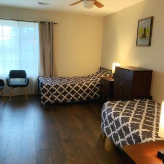 A tidy bedroom with two single beds and wooden flooring.