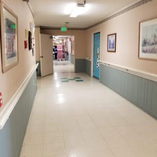 A corridor with artwork on the walls, leading to an open doorway.