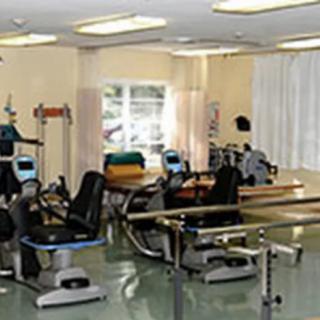 A rehabilitation room equipped with various exercise machines for physical therapy.
