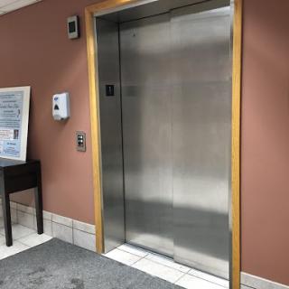 An elevator door in a commercial building, featuring a sleek metal finish.