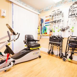 A well-equipped rehabilitation room featuring exercise bikes and mobility aids.