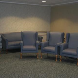 A seating area with blue chairs and a sofa in a waiting room.