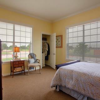 A cozy bedroom with large windows allowing plenty of natural light.