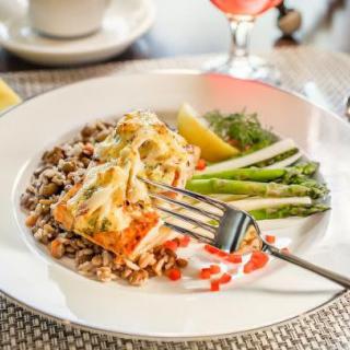 A delicious meal of salmon fillet served with asparagus, rice, and lemon wedges.