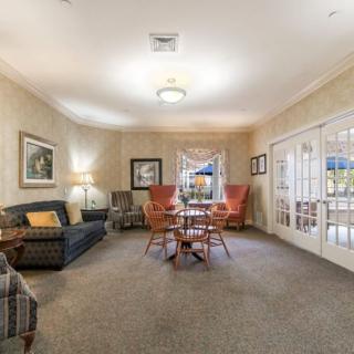 A cozy living room featuring sofas, chairs, and a table with soft lighting.
