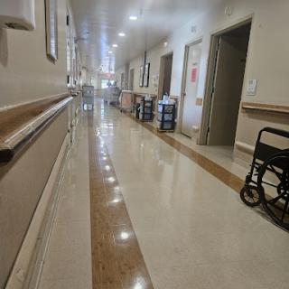 A quiet hospital corridor with a wheelchair parked on one side.