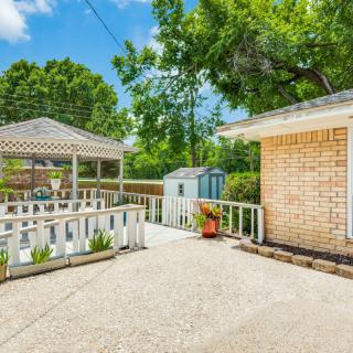 A bright backyard with a gazebo, patio area, and surrounding trees.
