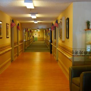 A well-lit hallway decorated with flags, featuring comfortable seating and warm wooden flooring.
