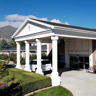 A building with a grand entrance featuring large columns and a driveway.