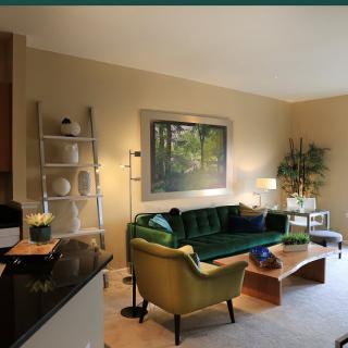 A modern living room with a green sofa, decorative shelving, and contemporary artwork.