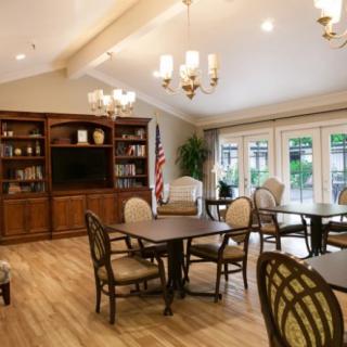 A cozy living room with elegant furniture, bookshelves, and a TV.
