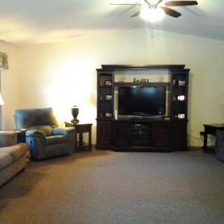 A cozy living room setup with a large entertainment center and comfortable seating.