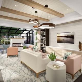 A modern living room with elegant furniture, a fireplace, and decorative wooden beams.