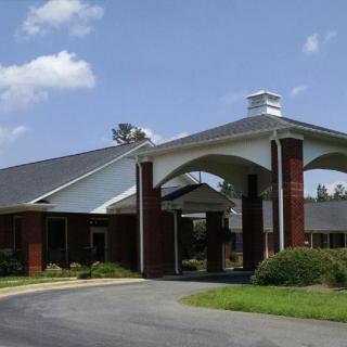 A building with a prominent entrance featuring arches, set against a blue sky.