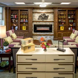 A cozy living room with a fireplace and built-in bookshelves, featuring comfortable seating and elegant decor.