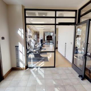 A stylish and modern office space featuring glass doors and a well-lit design.