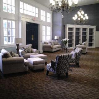 A spacious lounge area with comfortable seating and elegant chandeliers.