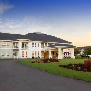 A large and elegant mansion with a well-maintained driveway and garden.