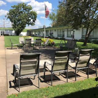 A peaceful outdoor seating area featuring a fire pit and an American flag, perfect for relaxation.