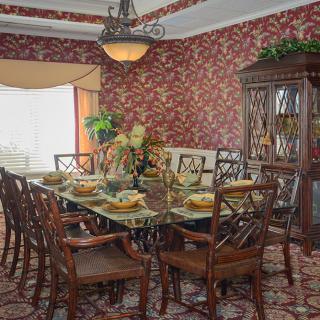 An elegantly decorated dining room with a set table and classic furnishings.
