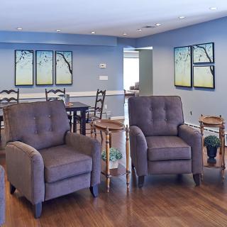 A cozy living room featuring a pair of upholstered chairs and wall art.