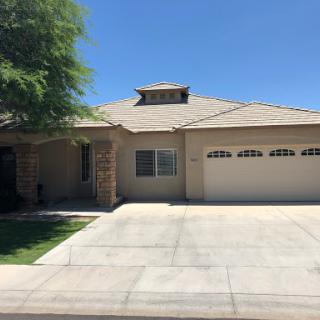 A well-maintained single-story house with a spacious driveway and a garage.