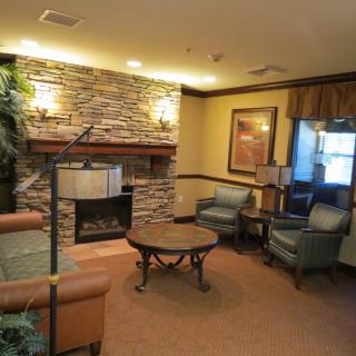 A cozy lounge area with comfortable seating and a stone fireplace.