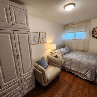 Cozy bedroom with a bed, armchair, and wardrobe.