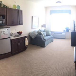 A cozy living space with a kitchenette and a sofa by a large window.