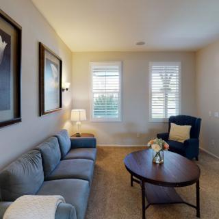 A cozy living room with a comfortable sofa, an armchair, and a coffee table.
