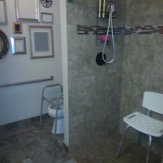 Accessible bathroom with shower chair and grab bars.
