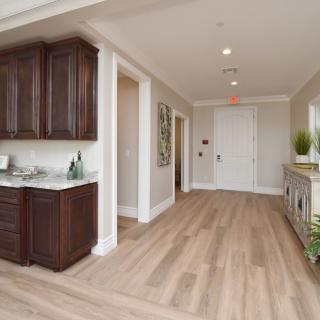 A modern hallway with wooden flooring and dark wooden cabinets.