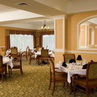 An elegant dining room with neatly set tables and plush chairs.
