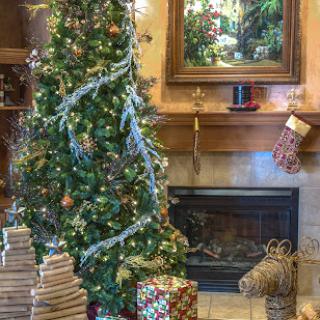 A beautifully decorated Christmas tree surrounded by wrapped presents and a cozy fireplace.