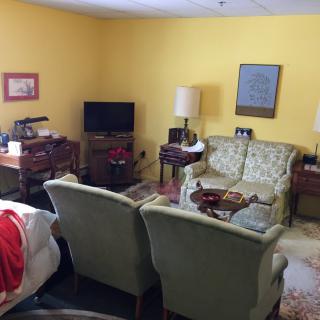 A cozy living room with vintage furniture and yellow walls.