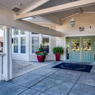 A welcoming entrance with a covered walkway and potted plants.