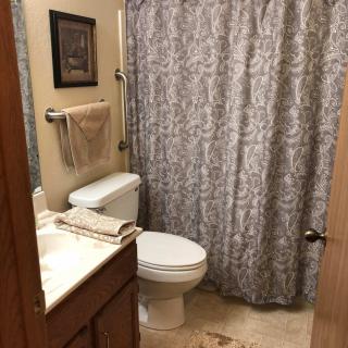 A small, neatly arranged bathroom with a patterned shower curtain.