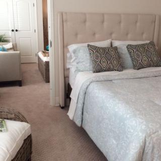 A cozy and well-decorated bedroom featuring a plush bed with patterned pillows and a soft comforter.