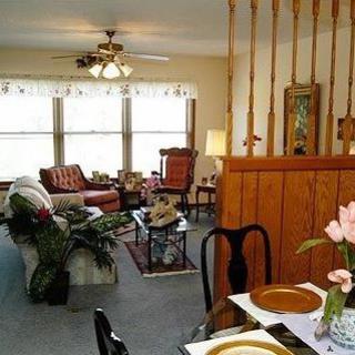 Cozy living room with a dining area, featuring classic furniture and warm decor.