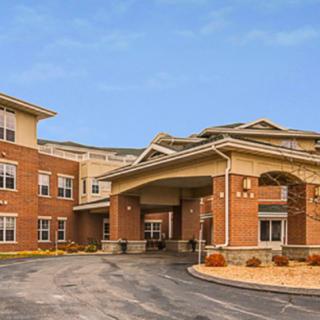 Modern brick building with a prominent entrance and clear sky.