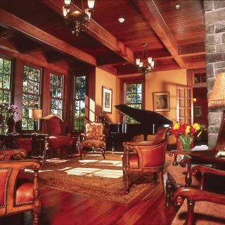 A luxurious and elegantly designed living room featuring a grand piano and wooden furniture.