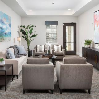 A modern and stylish living room featuring comfortable seating, elegant decor, and contemporary artwork.