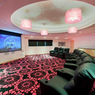 A cozy home theater room with comfortable seating and a large screen for an immersive viewing experience.