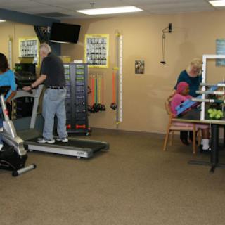 A rehabilitation center featuring individuals engaging in different forms of exercise.
