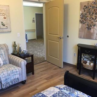 A cozy living room with a comfortable chair, small table, and decorative elements.
