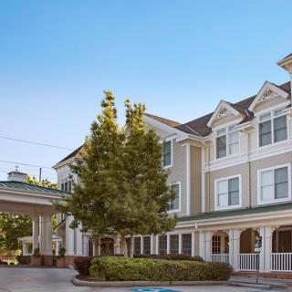 A daytime view of a hotel building with classic architecture and surrounding trees.