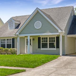 A charming single-story house with a well-maintained front yard and garage.