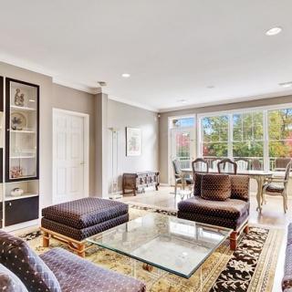 A well-lit living room with elegant decor and ample seating.