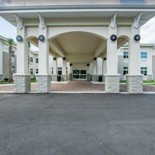 A modern building entrance with a covered walkway and columns.